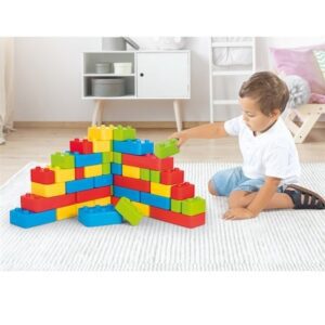 Dečak se igra sa šarenim plastičnim kockama u dnevnoj sobi Dolu igračke kocke za decu.