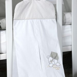 Torba za pelene Tri Drugara dečiji nameštaj i dekor bela torba sa sivim tačkicama i izvezenim medvedićem okačena na krevetac.